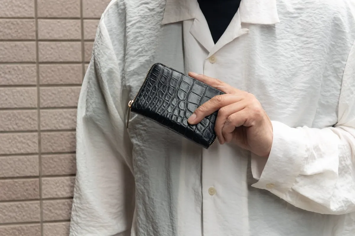 黒のクロコダイルL字ファスナー財布を手にする男性